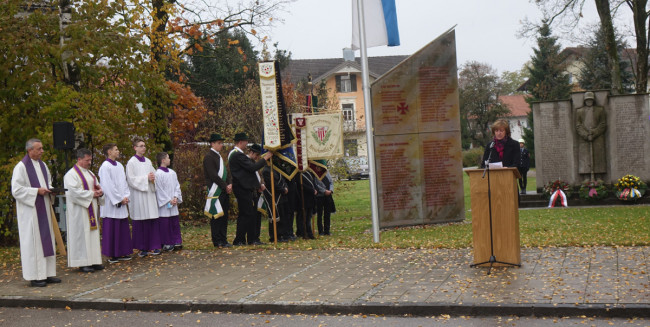 Pfarrer Andreas Strauß, Pfarradministrator Augustin Butacu mit Ministranten, Fahnenabordnungen der örtlichen Vereine, am Pult die 3. Bürgermeisterin der Marktgemeinde Bruckmühl, Anna Wallner